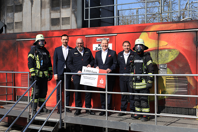 Vorstand Frank Opitz und Stabsleiter Dominik Heinrich überreichen eine Spende der Sparkasse Fürstenfeldbruck für die Finanzierung der Brandcontainer-Ausbildung der Atemschutzgeräteträger.